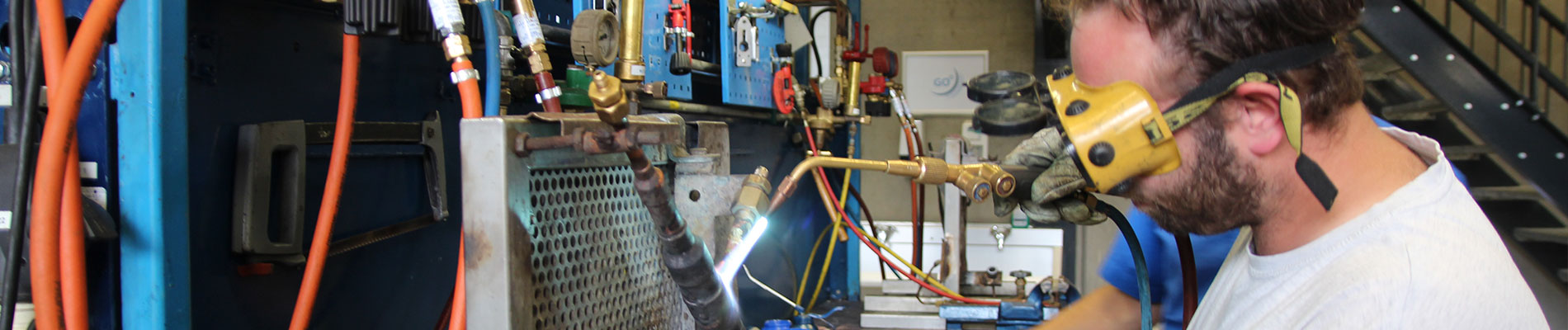 Man aan het solderen bij koelinstallatie