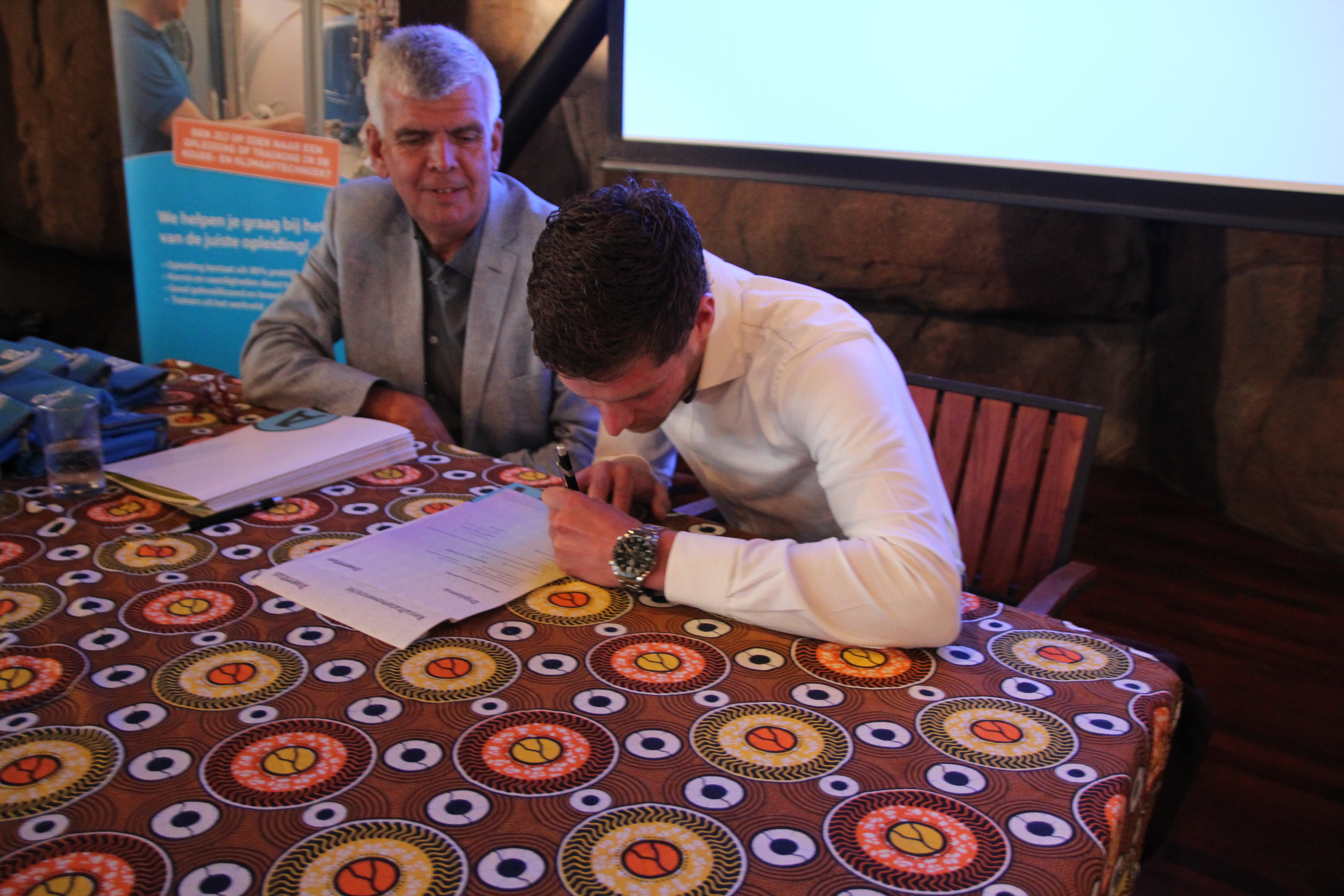 Diploma tekenen bij de uitreiking van Opleidingscentrum GO