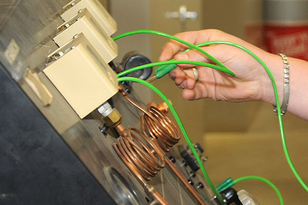 Hand met kabel bij een schakelbord