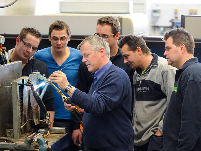 Docent toont lassen aan groep mannen 