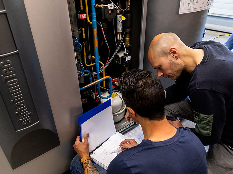 Mannen bestuderen warmtepomp