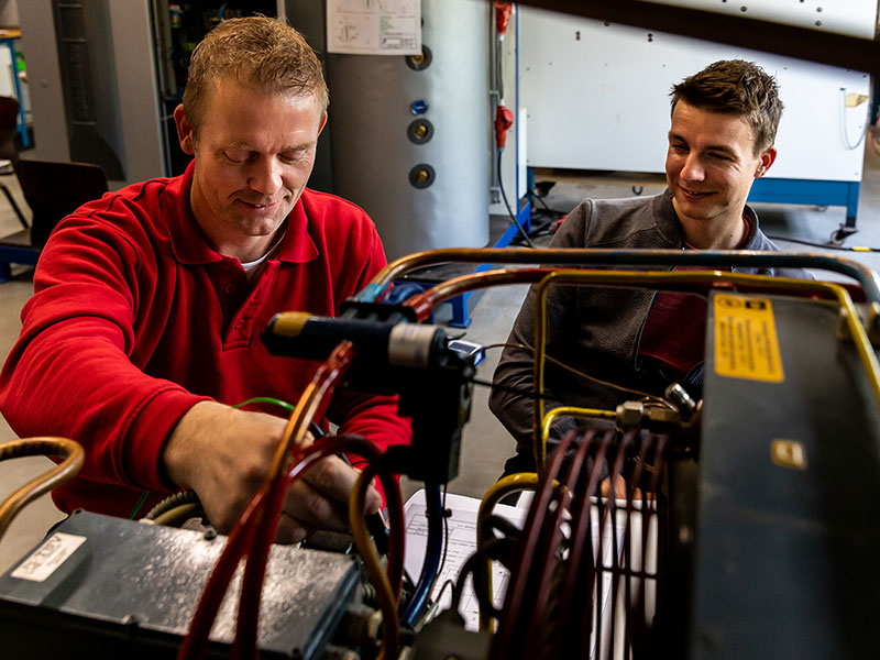 Twee mannen werken aan warmtepomp