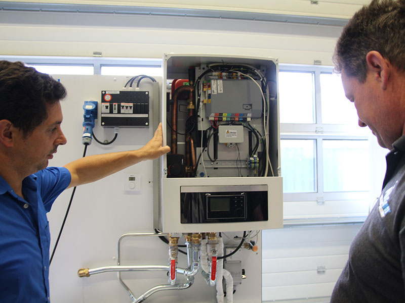 Twee mannen staan bij wamtepomp